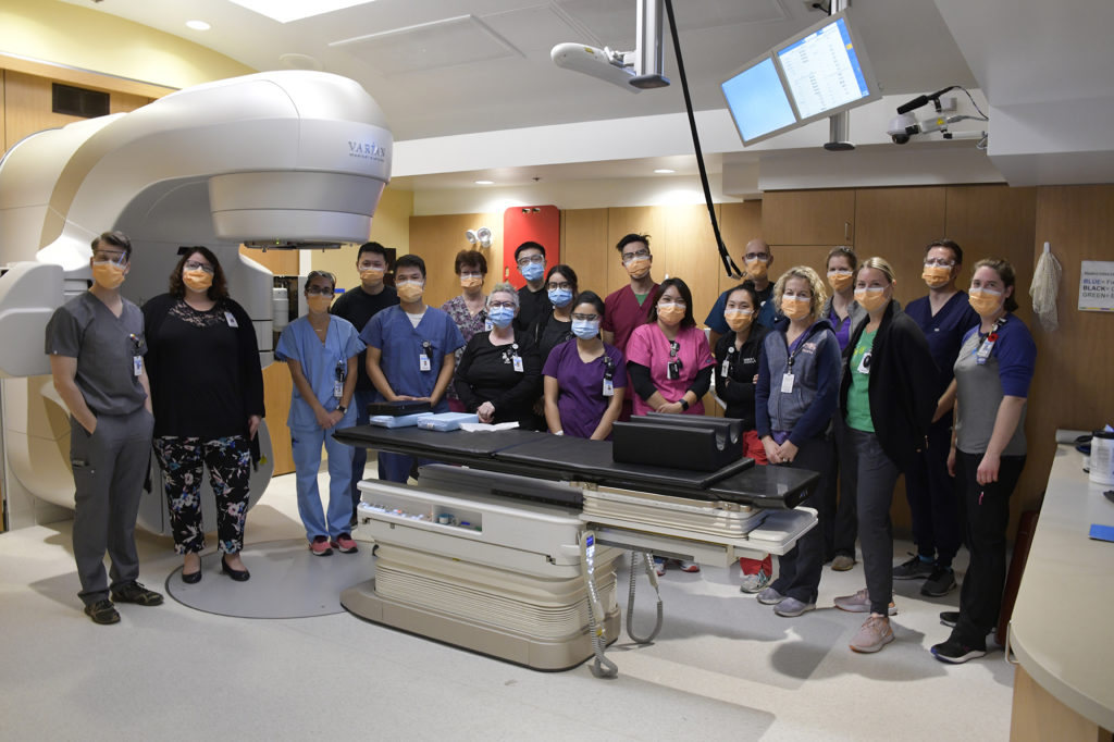 group of medical professionals around a machine